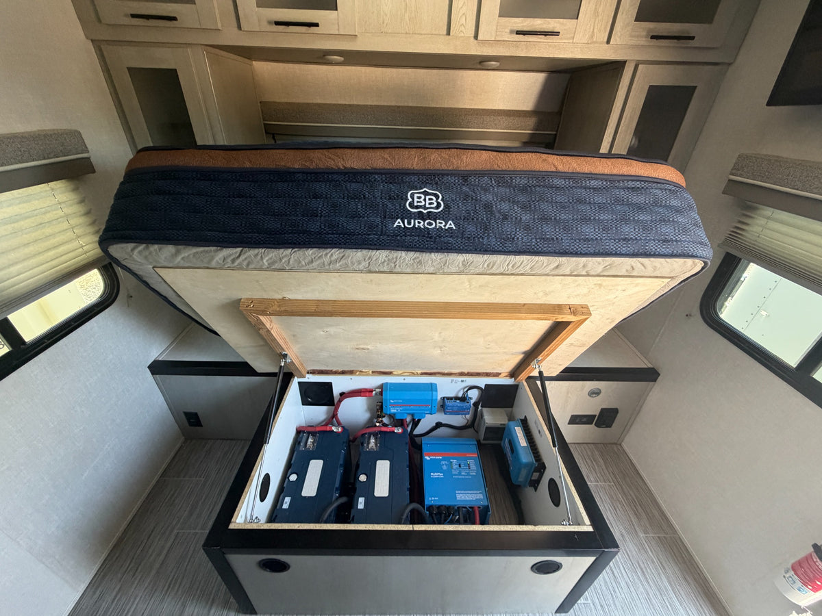 RV batteries, inverter and charging equipment installed beneath a lift-up bed