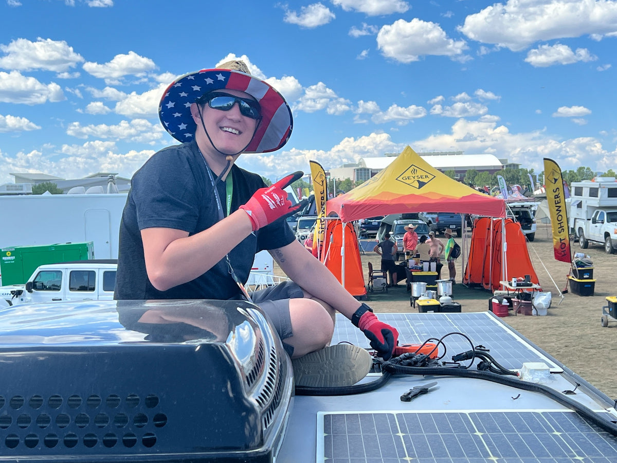 Jordan, founder of Echo One Adventures, working beside rooftop RV solar panels