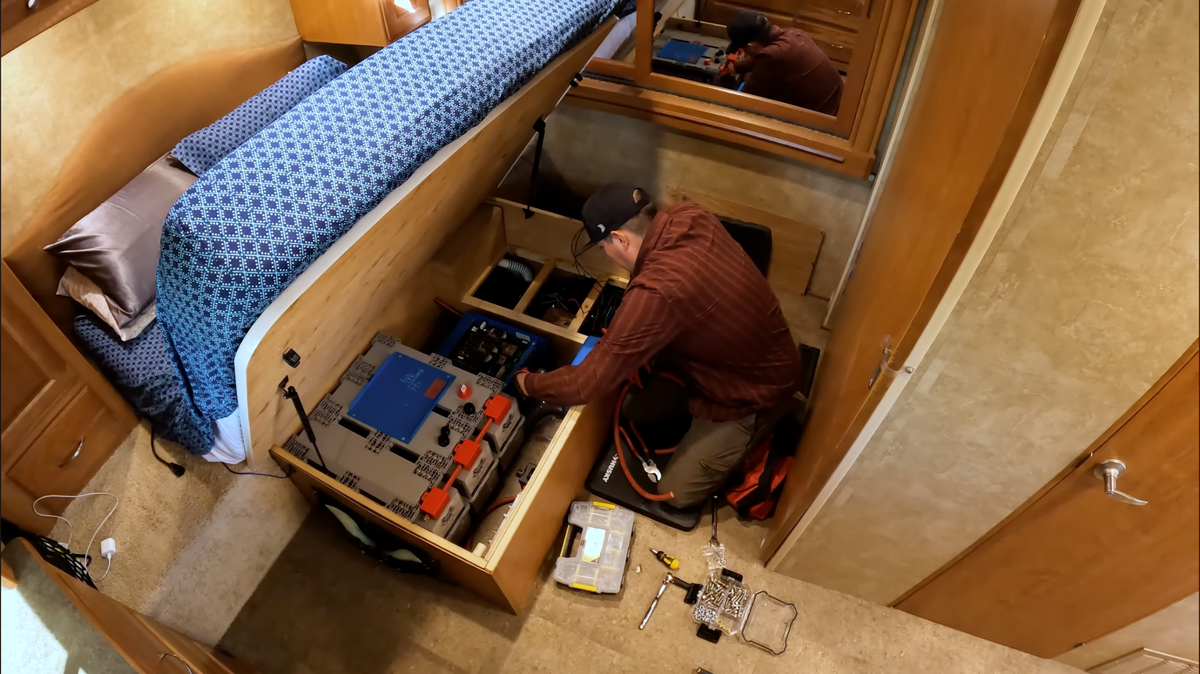 Jordan Madrid installing an electrical system beneath an RV bed